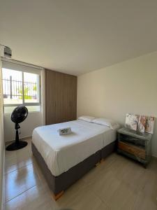 Acogedor Apartamento al oriente de Neiva في نيفا: غرفة نوم بسرير كبير ونافذة