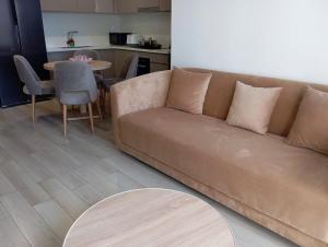 a brown couch in a living room with a table at Anna Vinhomes Grand Park in Ho Chi Minh City