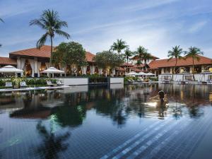 a person in a swimming pool at a resort at Sofitel Singapore Sentosa in Singapore