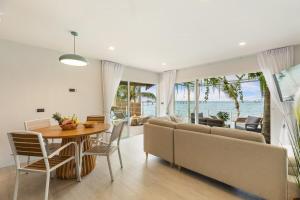 a dining room and living room with a table and chairs at Little Me Beachfront Villa in Nathon Bay