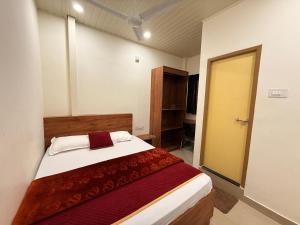 ein Schlafzimmer mit einem Bett mit einer rot-weißen Decke in der Unterkunft Port Inn Lodge in Mangaluru