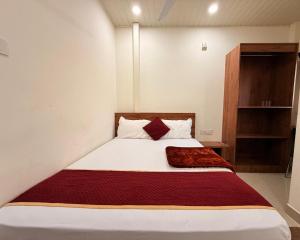 ein Schlafzimmer mit einem Bett mit einer roten Decke darauf in der Unterkunft Port Inn Lodge in Mangaluru