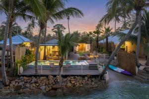 a house with a swimming pool and palm trees at Little Me Beachfront Villa in Nathon Bay