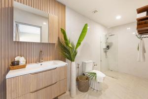 a bathroom with a sink and a vase with a plant at Little Me Beachfront Villa in Nathon Bay +73 photos