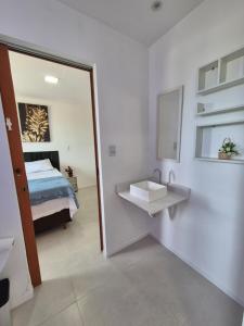 een slaapkamer met een bed, een wastafel en een spiegel bij Condomínio Residencial Tiê in Camassari +5 foto's