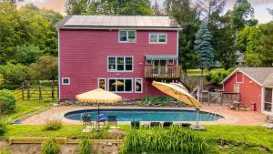 Historic Barn Retreat w Pool Pond Views Longview Pond Lodge by AvantStay في Clinton Corners: منزل احمر أمامه مسبح