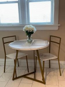 a vase of flowers sitting on a table with two chairs at The Cozy Luxe Retreat, Central West End in Saint Louis