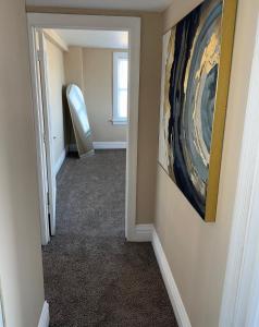 a hallway with a painting on the wall and a mirror at The Cozy Luxe Retreat, Central West End in Saint Louis