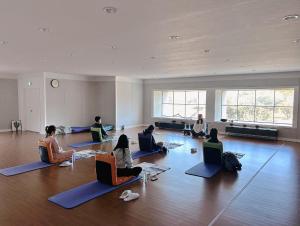 제주 신성의 숲 웰니스 호텔 في Haean: مجموعة من الأشخاص يجلسون على الأرض في غرفة مع أجهزة الكمبيوتر المحمولة الخاصة بهم