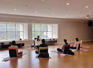 제주 신성의 숲 웰니스 호텔 في Haean: مجموعة من الناس يجلسون في درس اليوغا