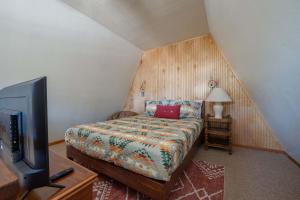 a bedroom with a bed and a flat screen tv at Rustic Mountain Getaway~Golf~Skiing~Hiking in Angel Fire +30 photos