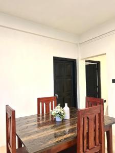 a wooden table with two chairs and a vase of flowers at Mareenda's Haven in Shillong +4 photos
