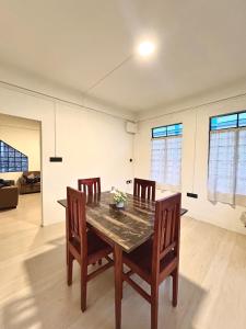 a dining room with a wooden table and chairs at Mareenda's Haven in Shillong