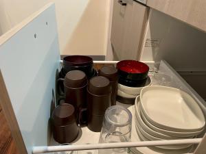 een lade vol met potten, pannen en borden bij KUSUO HOUSE Roji in Sapporo