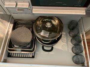 een kom en andere spullen in een open koelkast bij KUSUO HOUSE Roji in Sapporo