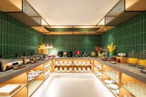 Una cocina con paredes verdes y un mostrador con comida. en Qiuguo Hotel Xi'an Bell and Drum Tower Yongning Branch, en Xi'an