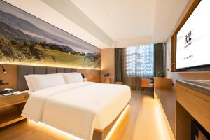 Una habitación de hotel con una cama y un televisor de pantalla plana. en Qiuguo Hotel Xi'an Bell and Drum Tower Yongning Branch, en Xi'an