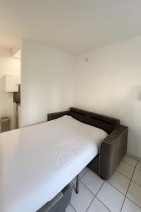 Ce lit se trouve dans un dortoir doté d'un matelas blanc. dans l'établissement Studio cosy à 5 min de la mer, à Antibes