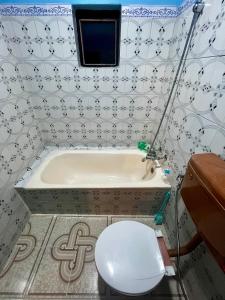 un baño con inodoro y bañera en Amelie Apartments and Stay Inn, en Pokhara