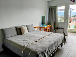 a bedroom with a bed and a table and a window at Un Sueño Valle de Huajes in Oaxaca City