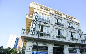 a white building with a sign on the side of it at Hotel Monarch in Elbasan
