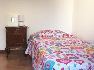 ein Bett mit einer Decke in einem Schlafzimmer in der Unterkunft Casa da Princesa in Vila Real de Santo António