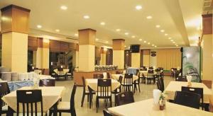 a dining room with tables and chairs and a unintention at Western Grand Hotel Ratchaburi in Ratchaburi