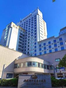 a large building with a sign in front of it at Fujian Galaxy Garden Hotel in Fuzhou