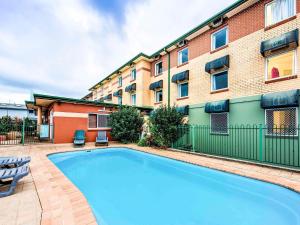 a swimming pool in front of a building at Coffs Harbour Budget Stay in Coffs Harbour