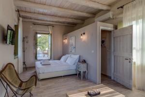 - une chambre avec un lit blanc et une fenêtre dans l'établissement Traditional Stonebuilt Villa Leonanto, only 5 Km from a Sandy Beach, à Kástellos