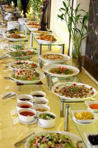 a buffet line of plates of food on a table at Siren Flower Hotel in Nha Trang