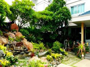 a garden in front of a house at Loei Orchid Hotel in Ban Tha Phae