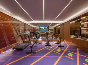 a room with a gym with a treadmill and a tv at Orange Nanjing Baijia Lake Xiaolongwan Subway Station Hotel in Jiangning