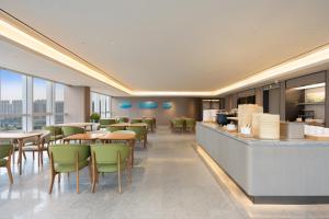a restaurant with tables and chairs and a bar at JI Hotel Hangzhou Xiaoshan Chaoyang Subway Station in Hangzhou
