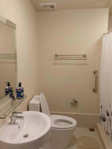 Luntian Luxury Condo in Tagaytay في Iruhin: حمام مع مرحاض أبيض ومغسلة