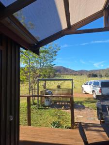 een veranda met een bank en uitzicht op een veld bij Milpa's Cottage Tandamuki in Moonambel