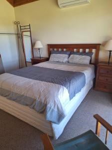 een slaapkamer met een groot bed en twee nachtkastjes bij Milpa's Cottage Tandamuki in Moonambel