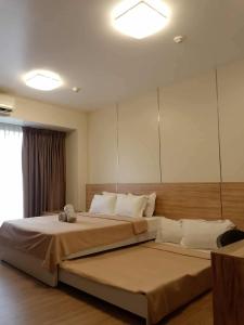 Luntian Luxury Condo in Tagaytay في Iruhin: غرفة نوم بسرير كبير ومرآة كبيرة