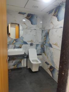 een badkamer met een toilet, een wastafel en een spiegel bij Januson Hotel in Koba