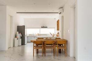 a kitchen with a wooden table and chairs at Villa Buho Ungasan - Luxury Villa 4br in Ungasan