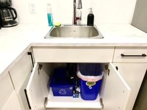 a kitchen cabinet with a sink and a trash can at Royal Oak in Winnipeg +34 photos