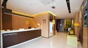 a lobby of a building with a woman sitting at a counter at IU Hotel Zhengzhou Xinzheng Sias International University Branch in Xinzhengzhan