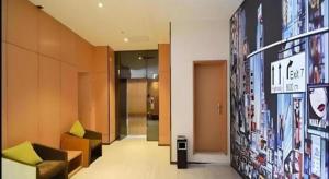 a lobby with couches and a sign on a wall at IU Hotel Zhengzhou Xinzheng Sias International University Branch in Xinzhengzhan