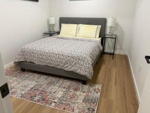 a bedroom with a bed with a rug and two lamps at Royal Oak in Winnipeg