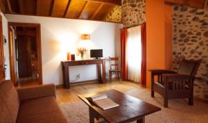ein Wohnzimmer mit einem Sofa und einem Tisch in der Unterkunft Hostal Casa Masip in Ezcaray