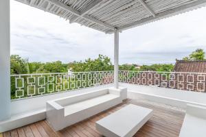 a balcony with white furniture and a white railing at Villa Buho Ungasan - Luxury Villa 4br in Ungasan