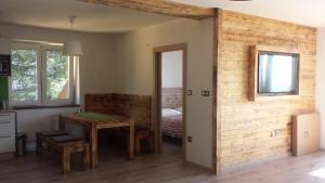 a room with a table and a room with a bed at Apartmány Benecko 155 in Benecko