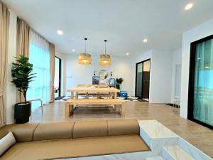 a living room with a couch and a table at Live With Passion Pool Villa in Pak Chong