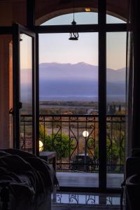 a bedroom with a view of the mountains through a window at Panorama Kakheti Resort in Gurjaani