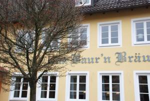 un edificio con un árbol delante de él en Altstadthotel Bauern Bräu Schrobenhausen en Schrobenhausen